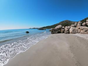 una playa de arena con rocas y el océano en Casa Stella Marina en Carbonia