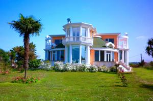 a large house with a palm tree in front of it at Villa Alba in Preveza