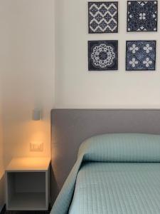 una camera con letto, comodino e foto appese al muro di Angelina Apartments Amalfi Coast a Maiori