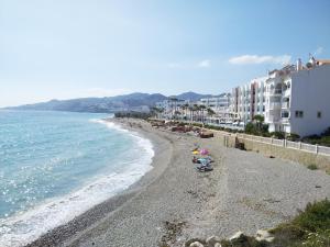 a beach with some buildings and the ocean at Apartamentos Turísticos Fercomar in Nerja