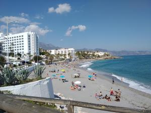 Grupa ludzi na plaży w pobliżu oceanu w obiekcie Apartamentos Turísticos Fercomar w mieście Nerja