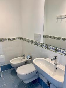 bagno con servizi igienici, lavandino e specchio di Angelina Apartments Amalfi Coast a Maiori