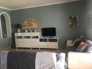 a living room with a couch and a flat screen tv at Casa vacanza borgo marinaro Santa Tecla complesso Le Sirene in Acireale