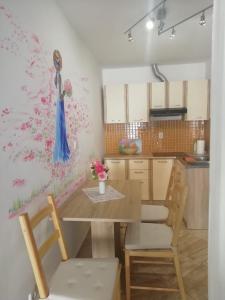 a kitchen with a table and chairs with a painting on the wall at Studio Rose in Pula