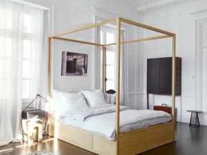 1 dormitorio con cama con dosel y almohadas blancas en Une Suite A Vannes en Vannes