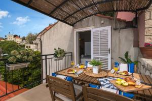 - une table sur un balcon avec de la nourriture dans l'établissement Apartments Olaf, à Dubrovnik