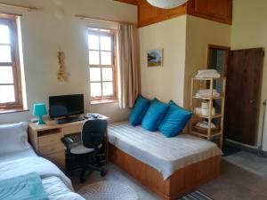 a bedroom with a bed with blue pillows and a desk at Amanitis Stone House in Kipoi