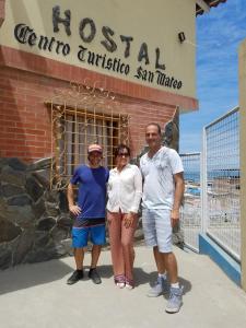 een groep van drie personen die voor een hotel staan bij Hostal Centro Turístico San Mateo in Manta