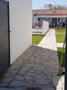 a stone walkway in front of a house at Appartement Aix (1 à 2 personnes) in Châtelaillon-Plage