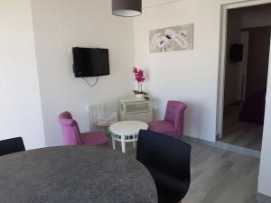 a dining room with purple chairs and a table at Appartement Aix (1 à 2 personnes) in Châtelaillon-Plage