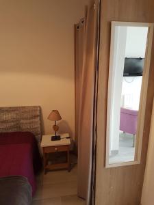 a bedroom with a mirror and a bed and a table at Appartement Aix (1 à 2 personnes) in Châtelaillon-Plage
