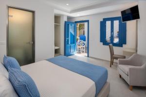 a bedroom with a bed and a chair at City Break in Fira