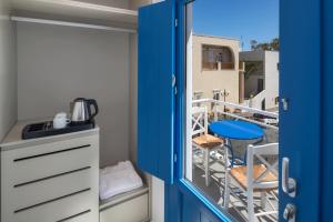 a blue door leading to a balcony with a table and chairs at City Break in Fira