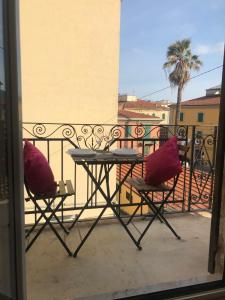 stół i krzesła na balkonie z palmą w obiekcie Cinqueterre Manarola w mieście La Spezia