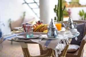 un tavolo con un piatto per la colazione di cibo sopra di Dar Sami, Riad Bab Kasbah a Tangeri