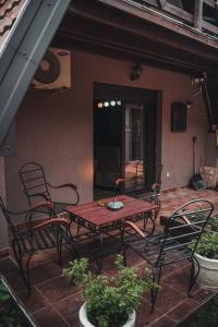 une table et des chaises assises sur une terrasse dans l'établissement Viola i Detelina Apartments, à Perućac