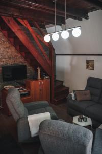 a living room with two couches and a tv at Viola i Detelina Apartments in Perućac