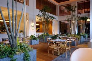 a restaurant with tables and chairs and plants at The Establishment Bangsar in Kuala Lumpur
