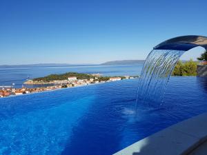 a swimming pool with a water fountain on the side of a building at Villa Afrodita in Makarska