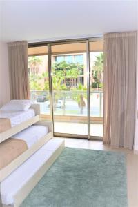 a bedroom with two beds and a large window at Salgados Beach&Golf - Praia dos Salgados in Albufeira