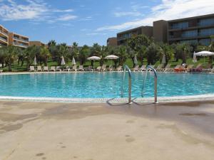 uma grande piscina com cadeiras e guarda-sóis em Salgados Beach&Golf - Praia dos Salgados em Albufeira