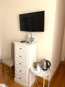 a white dresser with a flat screen tv on a wall at Quinta de Canhões in São Pedro do Sul