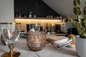 a table with two wine glasses and a cactus at Du Coté de chez Jeanne, Suite in Verviers