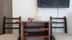 a table with a bottle of wine and two chairs at Kiara room in Mokošica