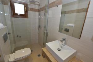 a bathroom with a sink and a shower and a toilet at Haus Katerina in Vourvourou