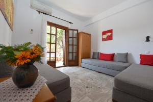 a living room with a couch and a vase of flowers on a table at Haus Katerina in Vourvourou