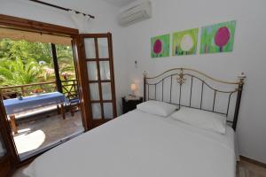 a bedroom with a bed and a sliding glass door at Haus Katerina in Vourvourou