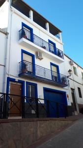 a white building with blue doors and balconies at VILLA MARIA in Vilches