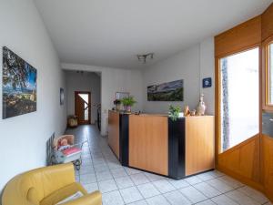 ein Wohnzimmer mit einem gelben Stuhl und einem Schrank in der Unterkunft Gästehaus Marion in Dettingen an der Erms