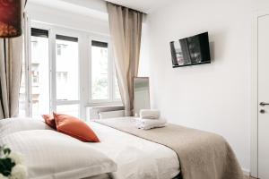um quarto branco com uma cama e uma janela em Nu-Apartments em Zagreb