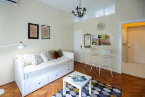a living room with a white couch and a table at Studio Jasna in Novi Sad