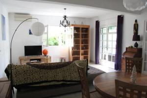sala de estar con sofá y mesa en Maison meublée avec piscine près du Lagon, en La Saline-Les-Bains