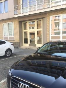 two cars parked in a parking lot in front of a building at Studio Hippique in Ostend