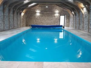 a swimming pool with blue water in a building at Les Fayettes in Montregard