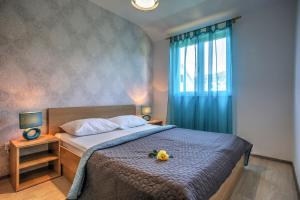 sypialnia z łóżkiem i oknem z kwiatem w obiekcie Apartment Ena 3 w mieście Betina