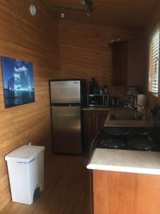 a kitchen with a stainless steel refrigerator and a sink at The Country Inn Cottage in Gander