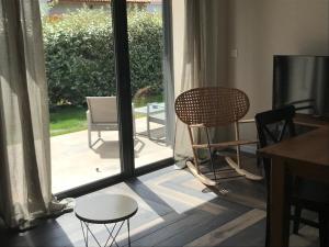 een kamer met een glazen schuifdeur met stoelen en een tafel bij Maison Corse in Aléria
