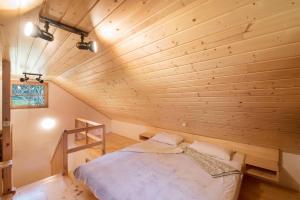 a bed in a room with a wooden wall at Little dream house in a perfect spot in Zalog