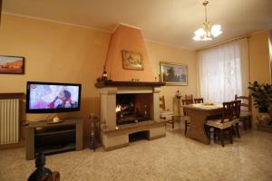 sala de estar con chimenea y TV en Affittacamere San Lorenzo, en Norcia