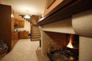 a living room with a fireplace in a kitchen at Affittacamere San Lorenzo in Norcia