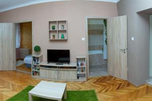 a living room with a television and a table at Kőrösi Apartman in Pécs