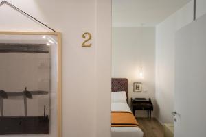 a room with a bed and a door with a number two on the wall at Relais Pensiero in Verona