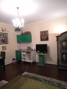 a living room with green cabinets and a television at Vila Kraljica in Vrdnik