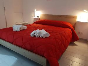 una camera da letto con un letto rosso con asciugamani sopra di La Siciliana Trapani Apartment a Trapani