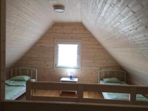a attic bedroom with two beds and a window at Świerkowy Zakątek in Sztutowo