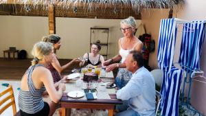 a group of people sitting around a table with a cake at Akiri Surf Retreat in Thulusdhoo